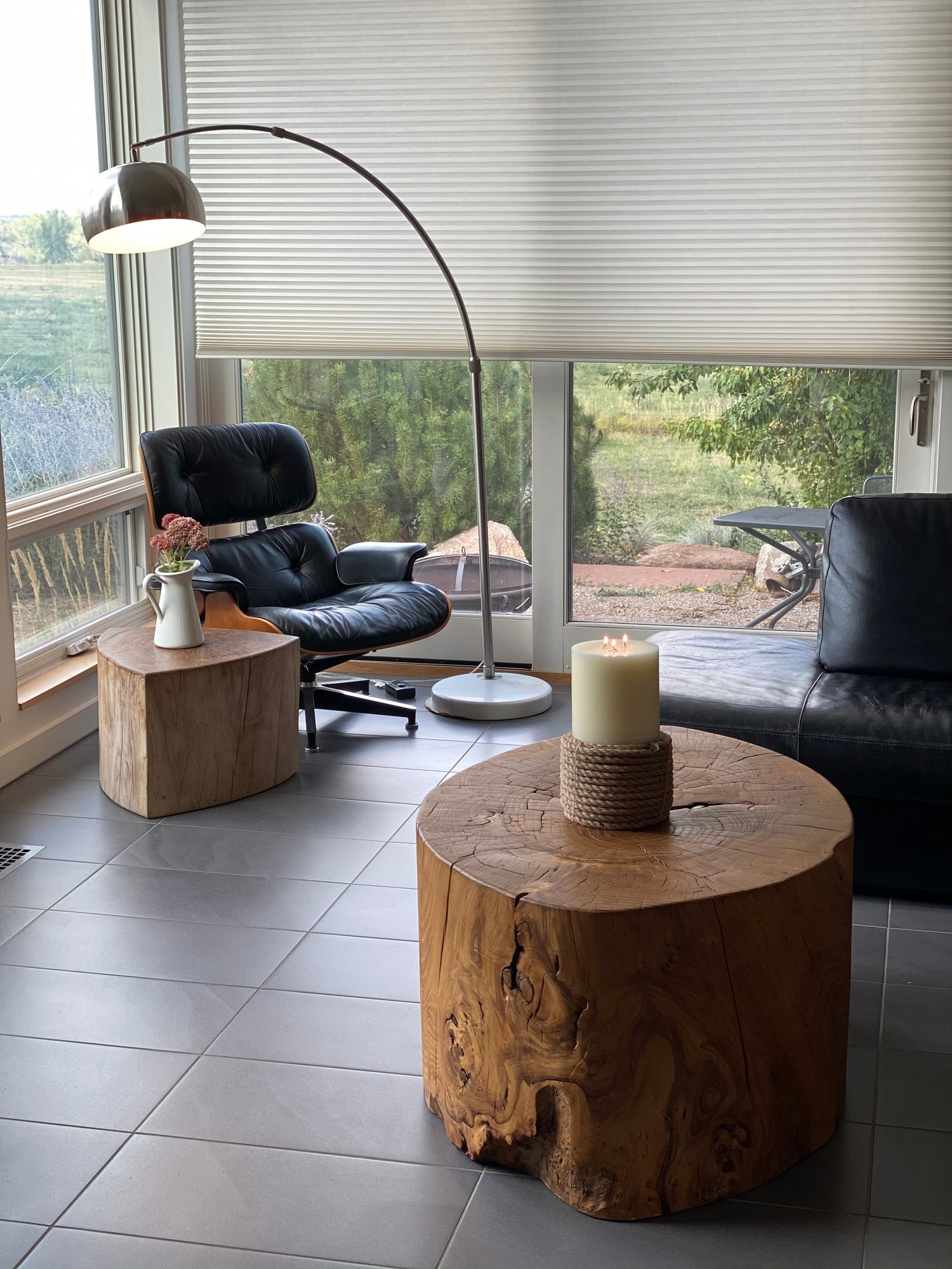Custom, hand-crafted ecoart furniture made by Tree Sky in Boulder, Colorado. A round wood table with a candlo on top, in an office with black leather chairs.